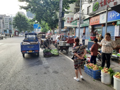 七星农贸市场临时摆摊,七星城管整治占道乱堆物料现象