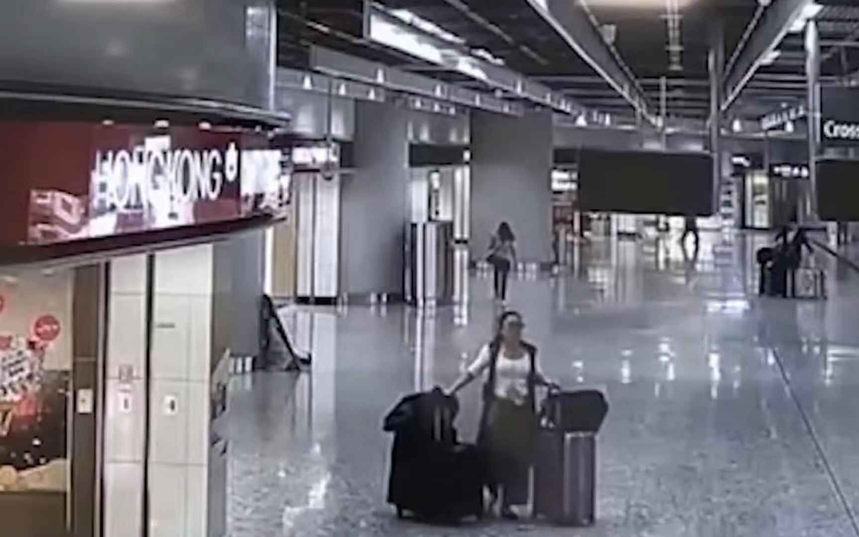 女子拿六个旅行箱过海关,一女子拿着行李箱