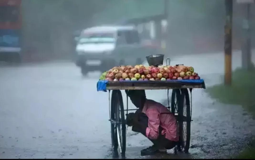 《避雨》里的美好，现实里没有，卖水果的小伙蜷缩在小推车下避雨