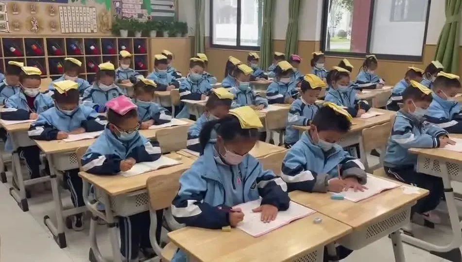 小学一年级写字要坐直,学生练字头顶毛巾